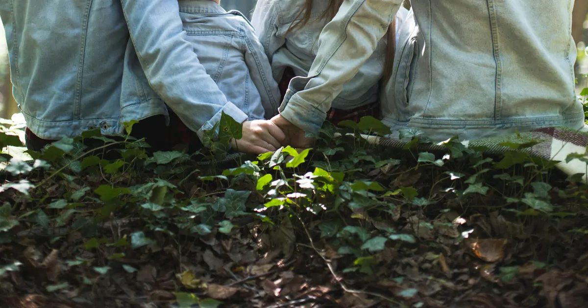 A family sitting together in a woodland clearing